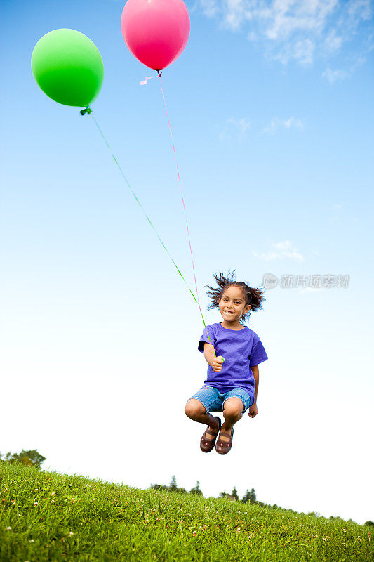 快乐的小女孩和气球在外面跳