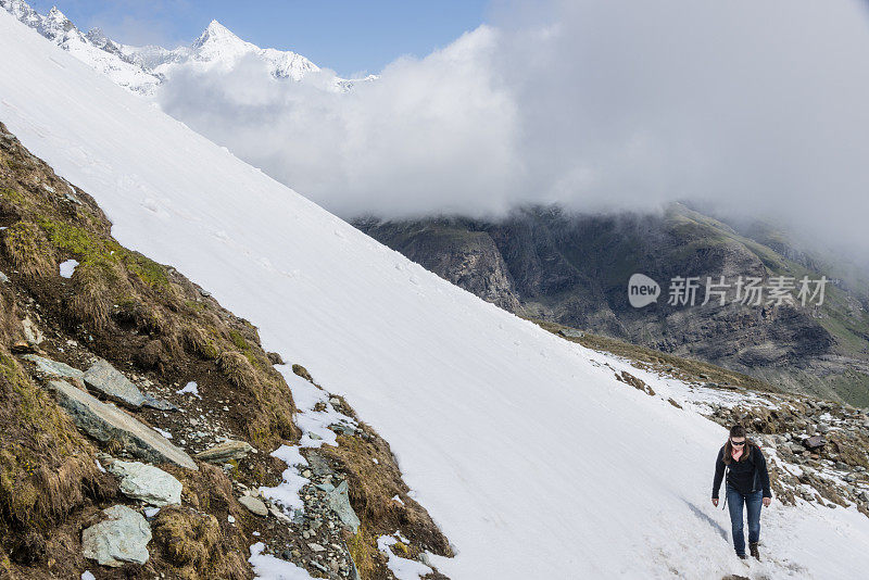 年轻女子徒步在积雪覆盖的山路-XXXL