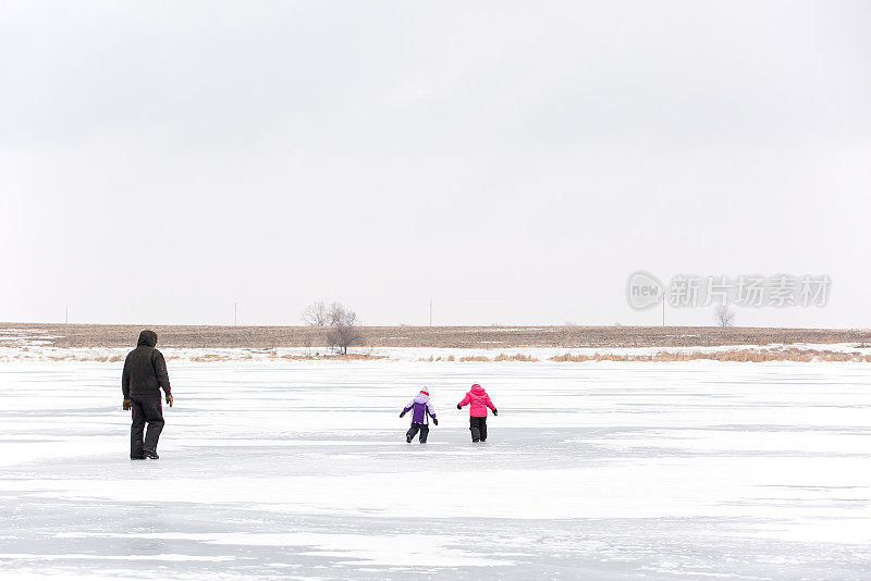 两个小女孩和走在冰上的爷爷