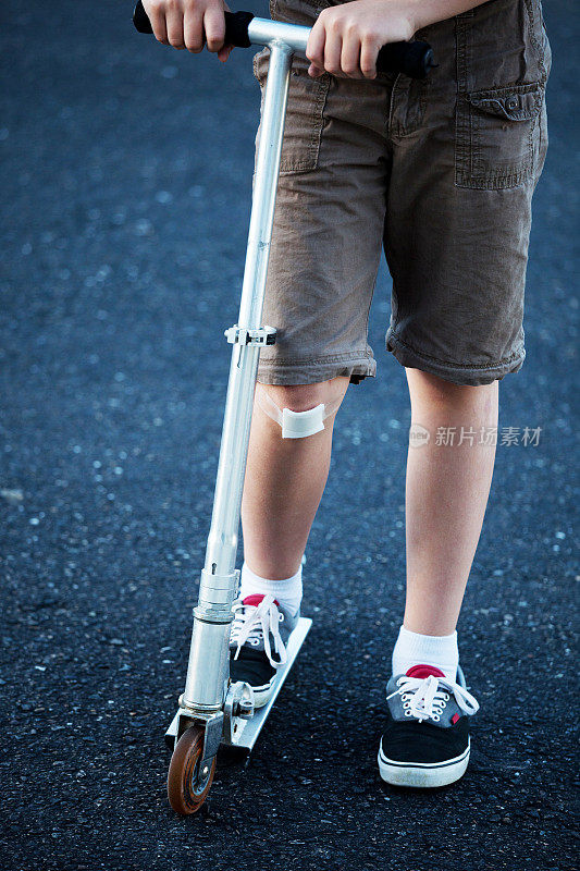 膝盖受伤的男孩骑摩托车的腿