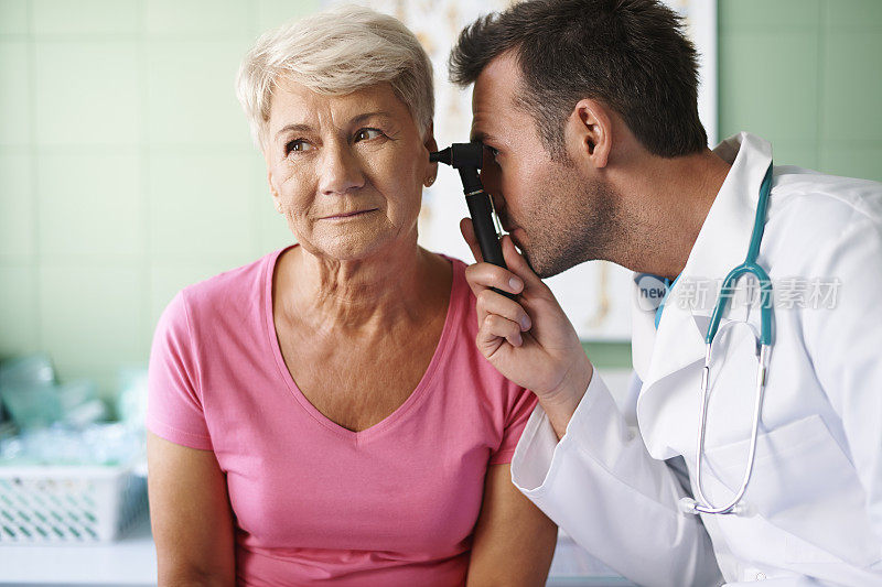 医生正在检查老年妇女的耳朵