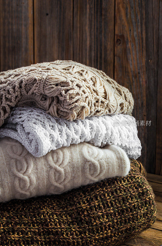 编织舒适的毛衣躺在木制的背景上