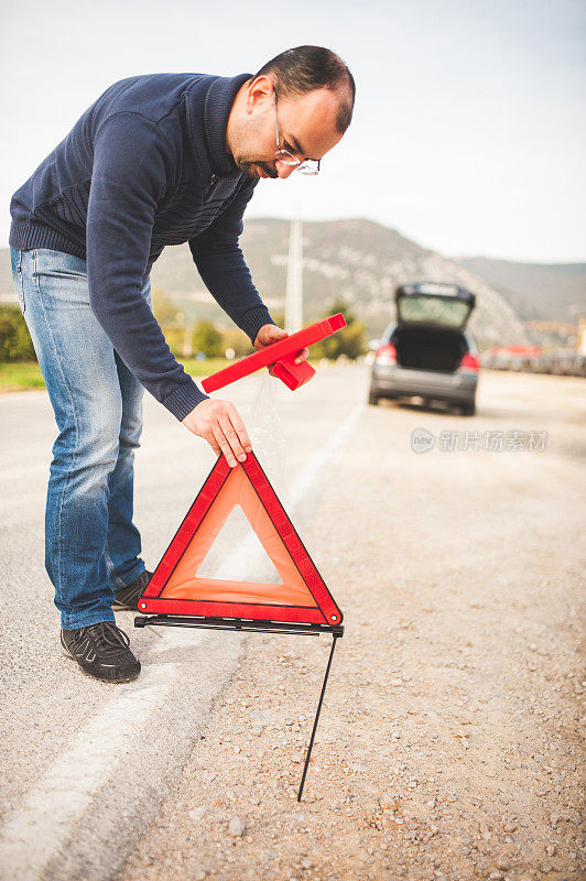 男子在道路上放置三角形警告标志