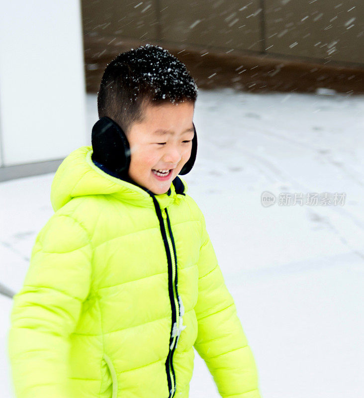 一个亚洲男孩在雪地里玩