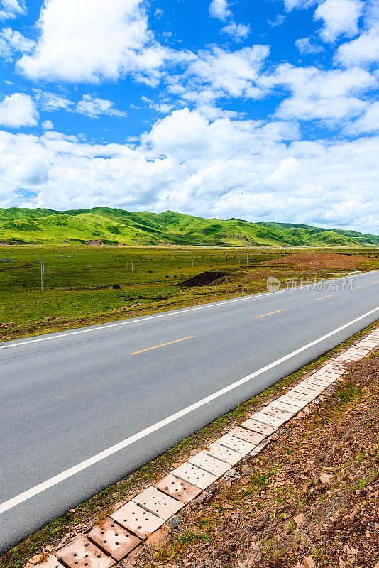 西藏高原的道路、草地和天空