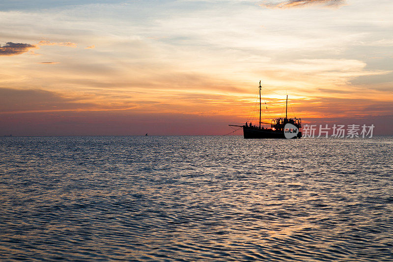 日落时海上小船的剪影