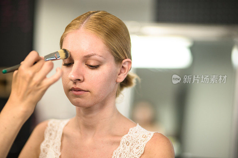 美丽的金发女孩肖像在化妆师