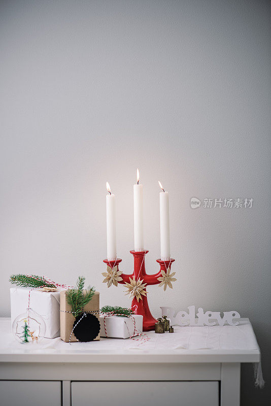 圣诞装饰品和包装好的礼物在烛光下