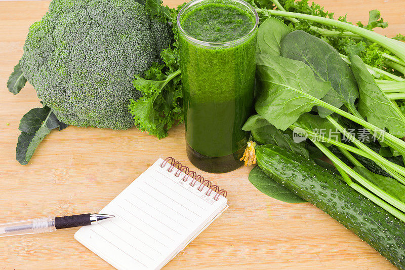 绿色蔬菜汁和空白笔记本