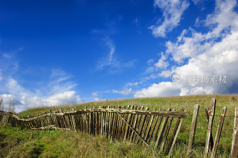 乡村木栅栏对抗多云的蓝天