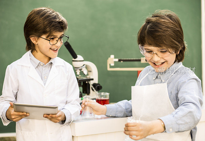 小科学家!小学生在科学实验上合作。