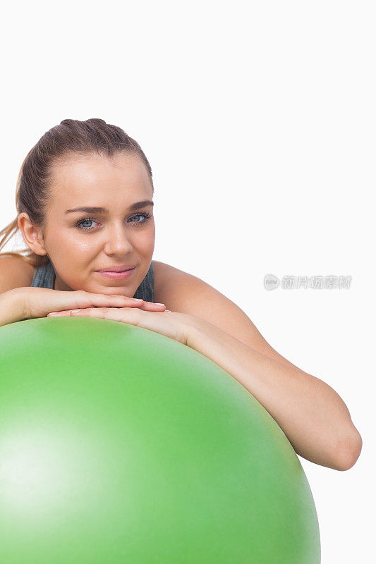 可爱的运动女人用健身球支撑自己