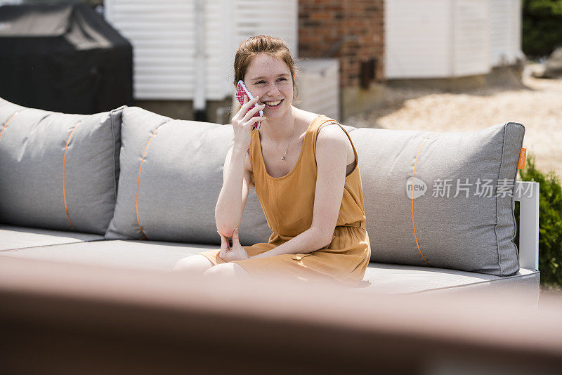 17岁的美丽少女在室外通过智能手机聊天