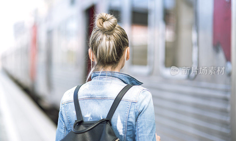 女子旅行者背包在火车站检查时间