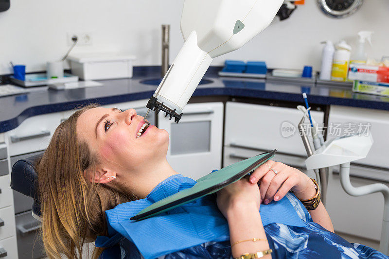 牙医或放射科医生用x光设备扫描病人的牙齿