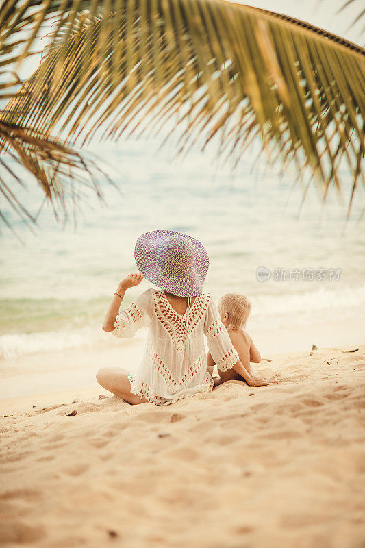 母亲和婴儿在热带海滩