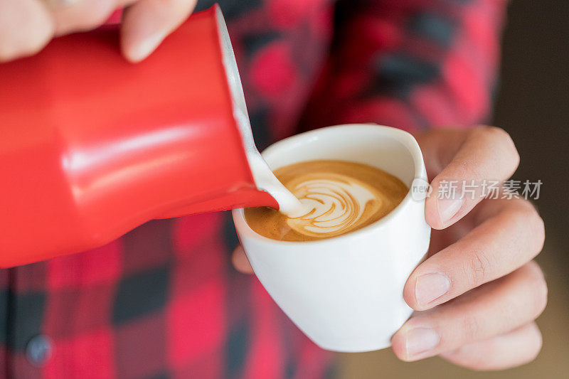 咖啡师往咖啡里倒牛奶