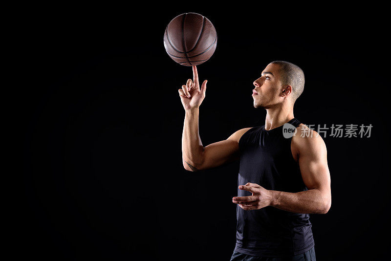 篮球运动员旋转球在手指上孤立黑色