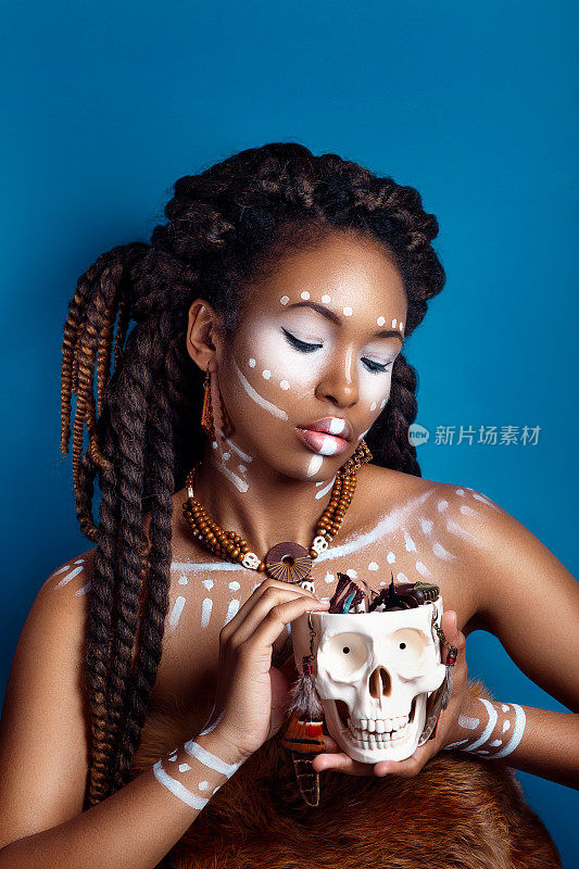 非洲风格的女人。迷人的年轻女子在民族珠宝。一幅画着脸的女人画像。创意的妆容和明亮的风格。