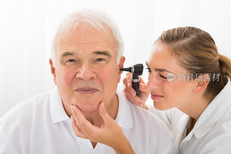 医生通过耳镜检查病人的耳朵