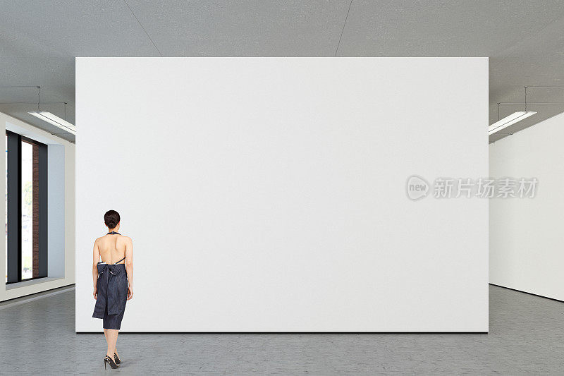 在现代画廊里看空白海报的女人