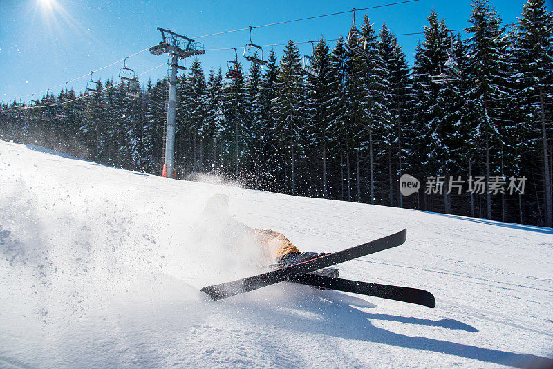 滑雪者跌倒在斜坡上的新鲜粉末雪在冬季度假村冒险极端肾上腺素活跃的生活理念