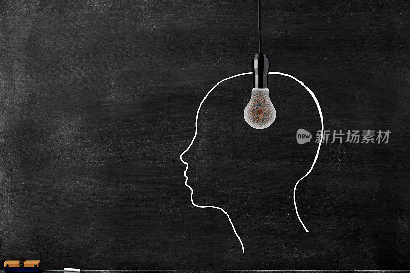 在黑板上画的人头前面挂一个装有金属齿轮的灯泡