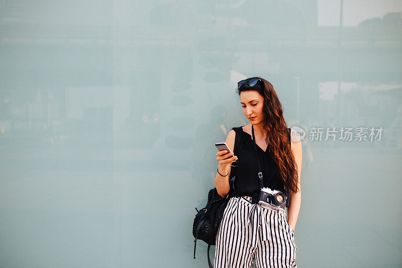 曼谷市中心的一名年轻女子，正在用手机发短信