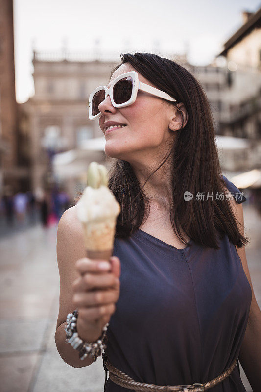 年轻女子发现意大利的维罗纳，走在街上，吃着冰淇淋