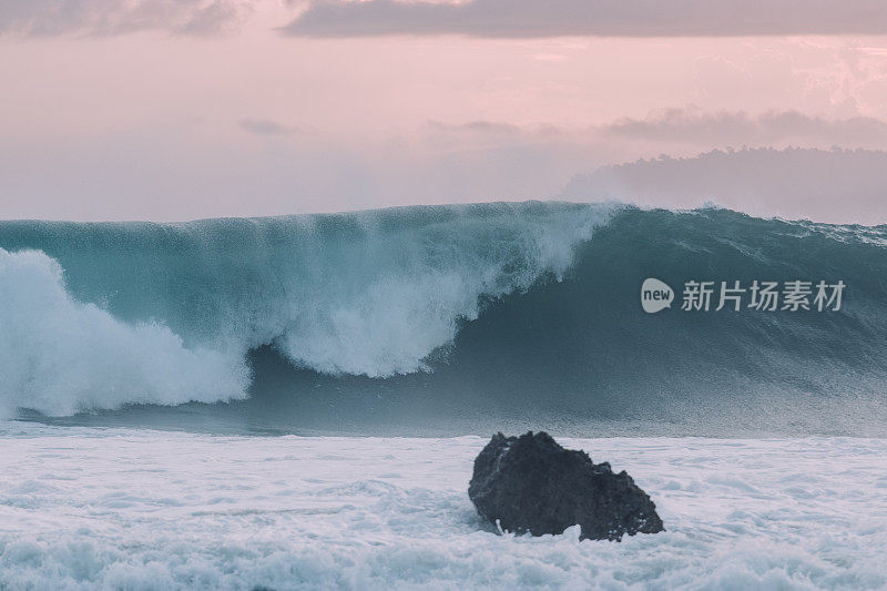 大浪与前面的岩石碰撞在一起