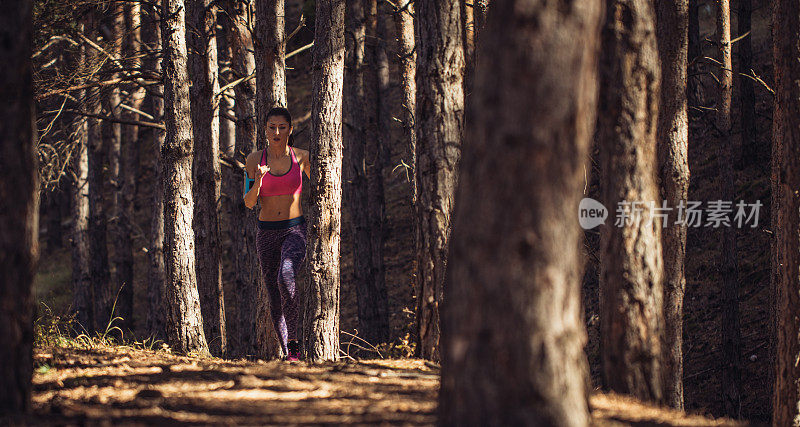 在森林里奔跑的年轻女子