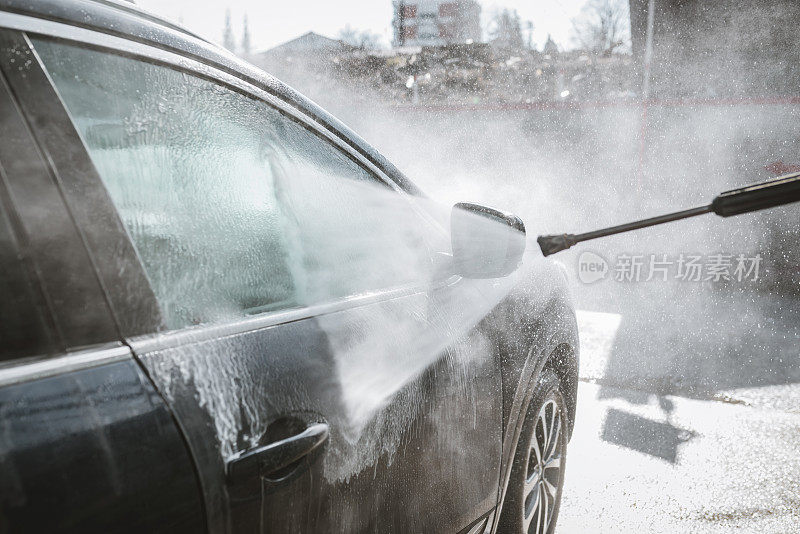 一名男子正在用高压清洗他的汽车