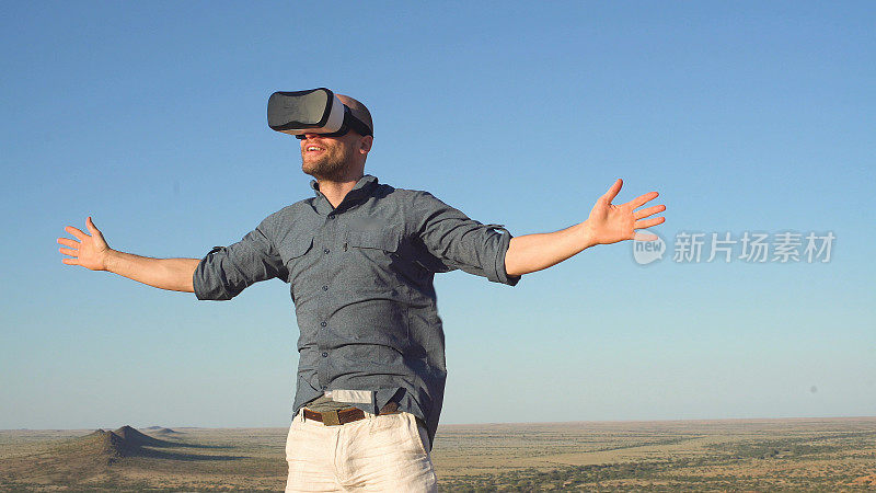 纳米比亚的沙丘上张开双臂的人。探索虚拟现实