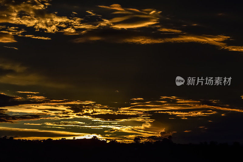 美丽的夏日天空，在金色的夕阳后，在山上