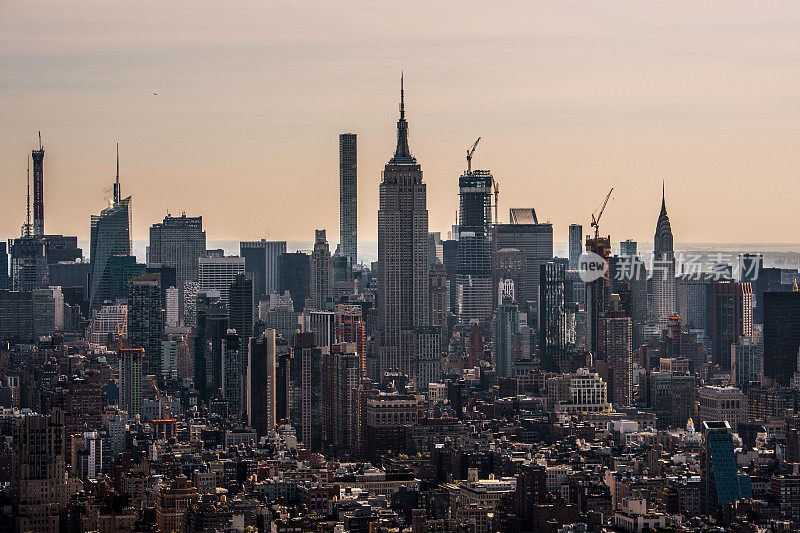 一架直升飞机在曼哈顿中城以帝国大厦为主导的城市景观拍摄