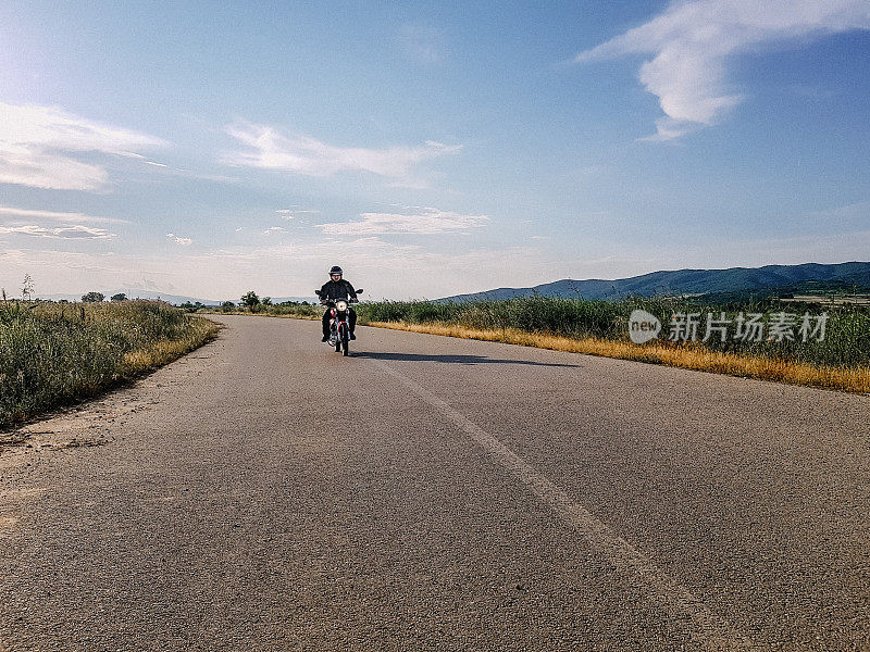 一个男人在高速公路上骑着摩托车