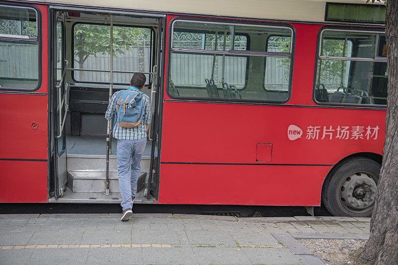 戴着耳机的年轻人正在上公交车