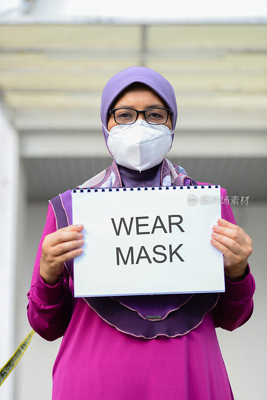 马来西亚医院前，医护人员戴着口罩举着标语