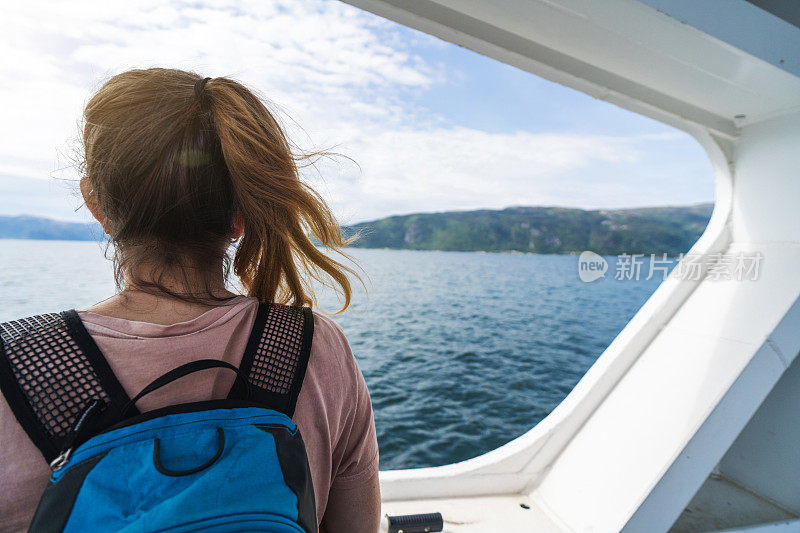 旅行女人的自由:头发在风中掠过渡船