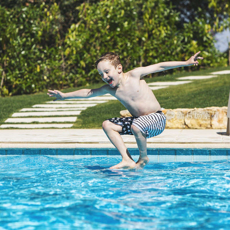 男孩在游泳池里跳