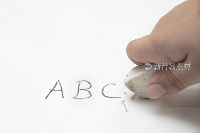 可爱的小男孩用橡皮擦擦ABC字
