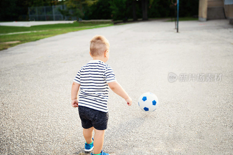 追逐足球的小男孩