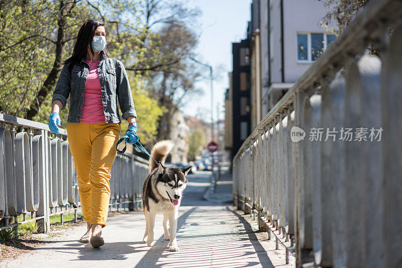 在隔离城市遛狗的女人