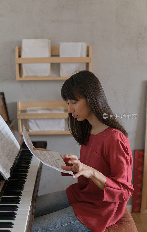 年轻女子在家里学习钢琴