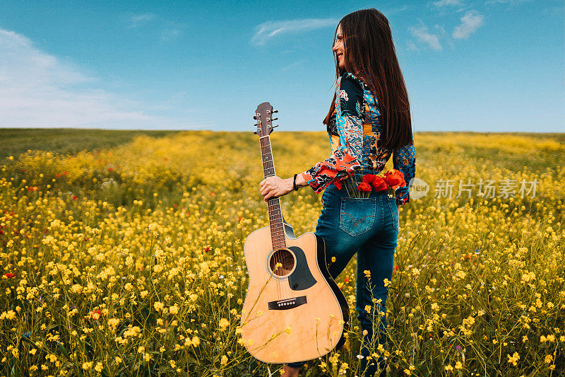 在一个阳光明媚的日子里，一个女人拿着一把吉他
