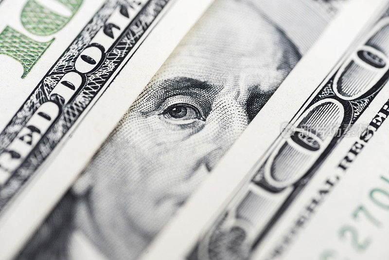 本杰明·富兰克林的眼睛从一张百元钞票上。百元钞票上本杰明·富兰克林的头像，背景，特写。只有本杰明·富兰克林眼睛的100美元钞票