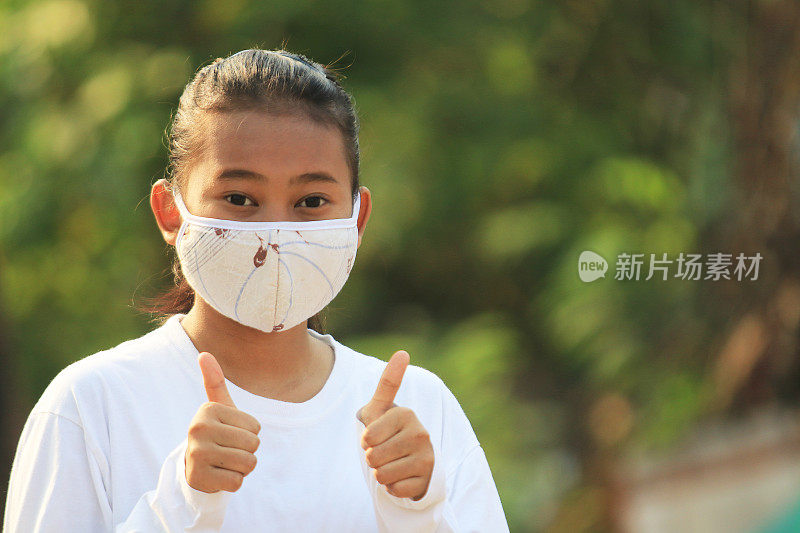 一名少女在冠状病毒大流行期间戴着面具微笑