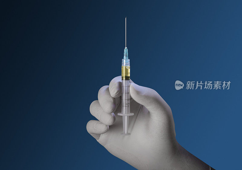 手戴防护手套，手持Covid-19疫苗注射器