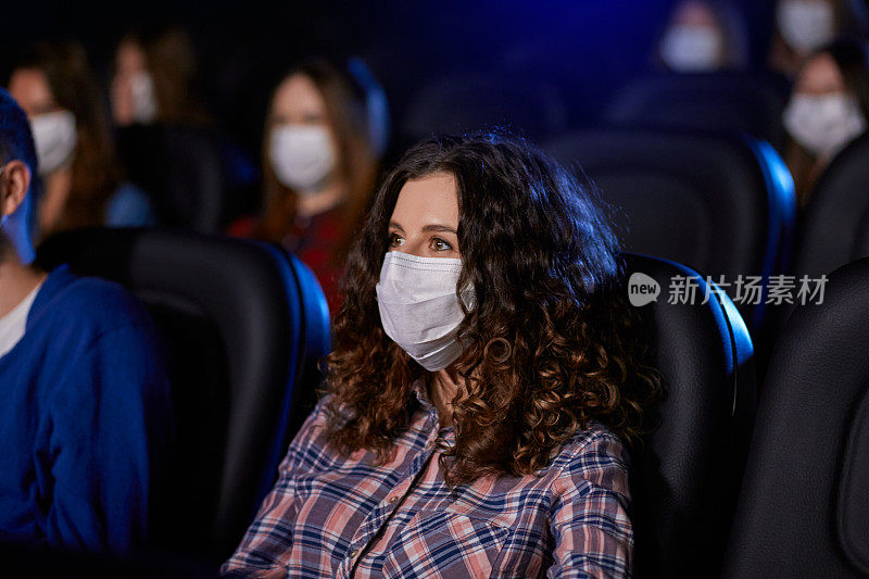 白人女人在电影院戴着面具。