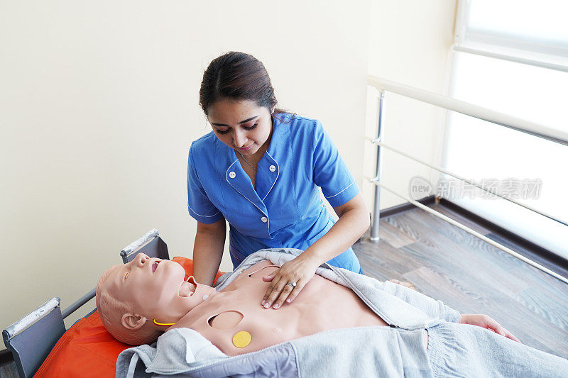 护理学生学习如何在紧急情况下抢救病人。心肺复苏术训练与心肺复苏术娃娃。